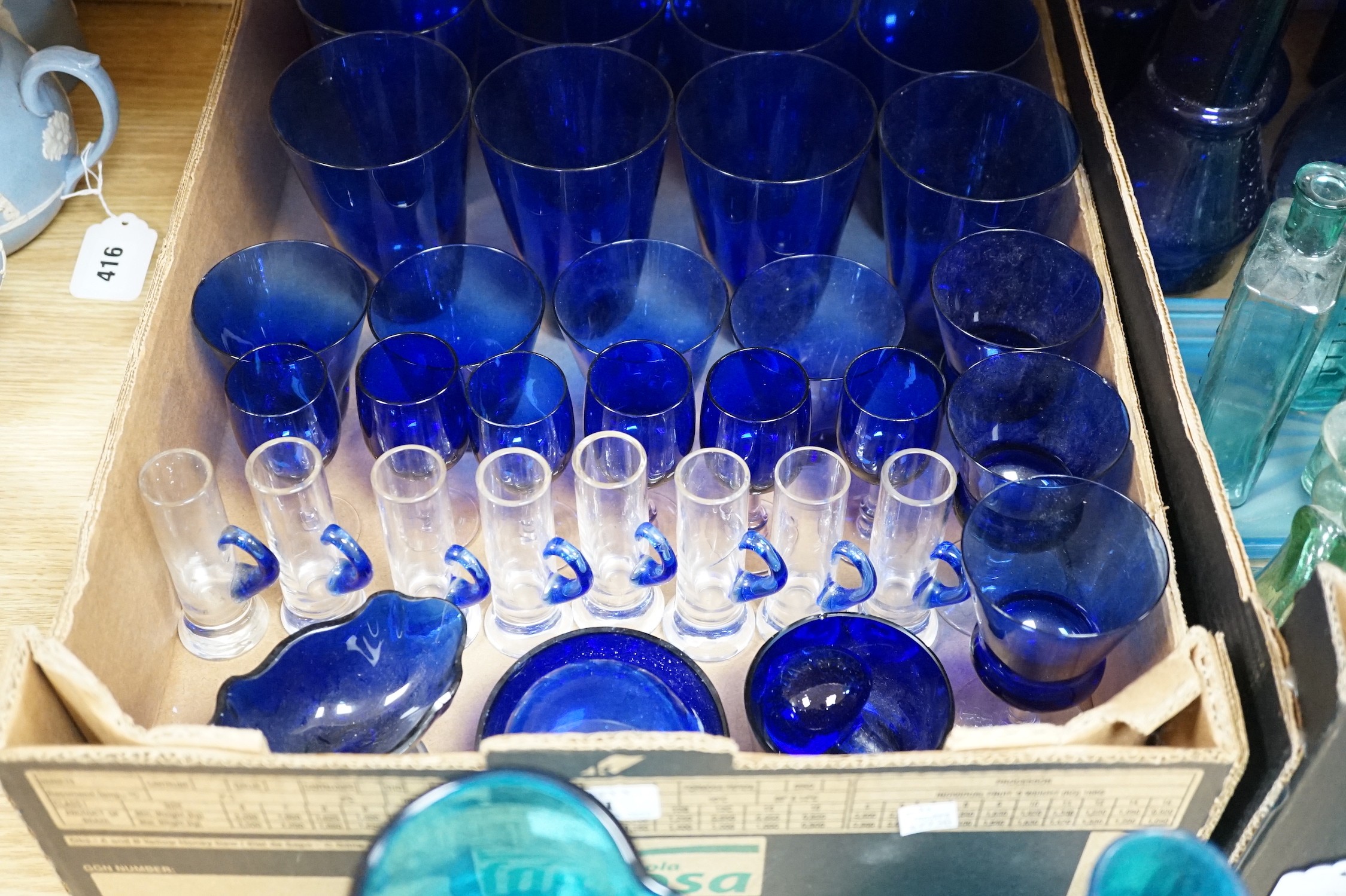 A collection of dark blue, green and turquoise coloured glassware, including three long stemmed glasses